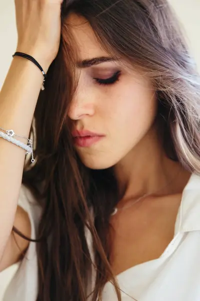 Depresif ağlayan genç kadın modeli üzerinde sarımsı arka plan izole güzel dalgalı saçlı closeup portresi. İnsani duygular kavramı.