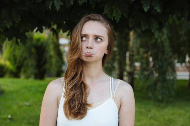 Güzel esmer kız komik yeşil arka plan üzerinde düşünüyor.