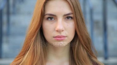 Uzun kızıl saçlı güzel kızgın üzgün genç kız portresi.