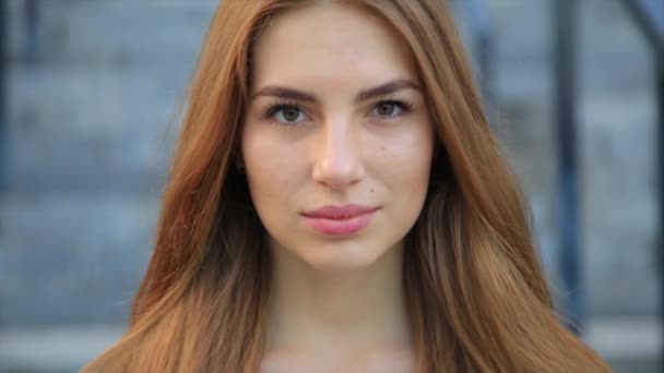 Retrato de mujer bonita mujer caucásica con el pelo largo sonriendo en la ciudad . — Vídeos de Stock