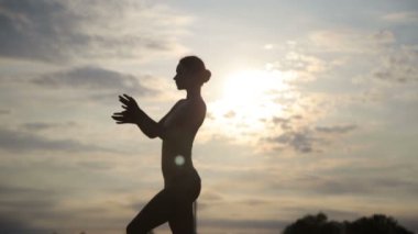 Genç güzel kadın giyiyor beden takım elbise çölde sunrise dans ediyor.