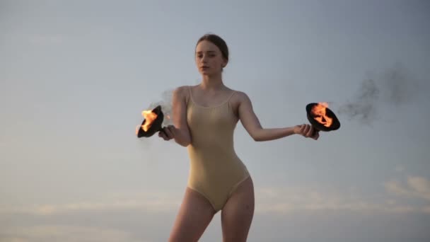 Junge schöne Frau tanzt mit Feuer im Ganzkörperanzug bei Sonnenaufgang in der Wüste — Stockvideo