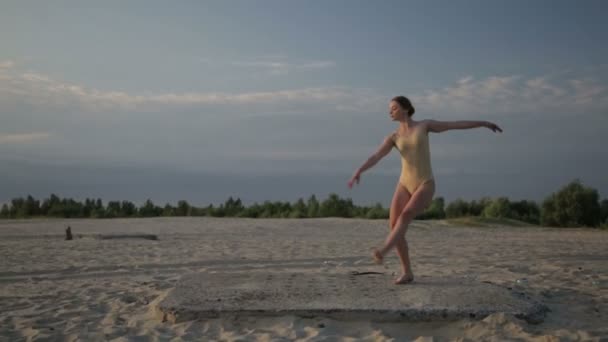 아름 다운 젊은 여자는 일출에 입고 바디 슈트 사막 춤.. — 비디오