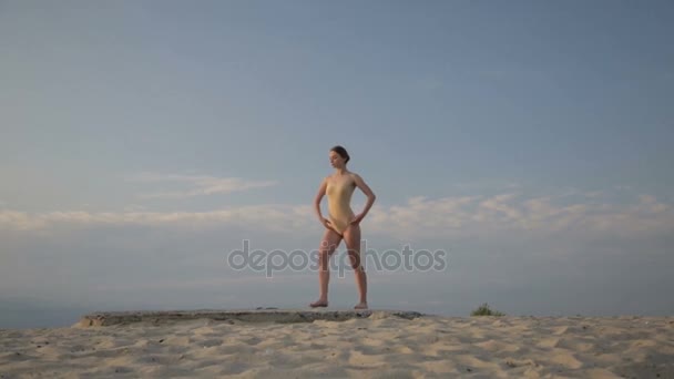 Junge schöne Frau tanzt im Ganzkörperanzug bei Sonnenaufgang in der Wüste. — Stockvideo