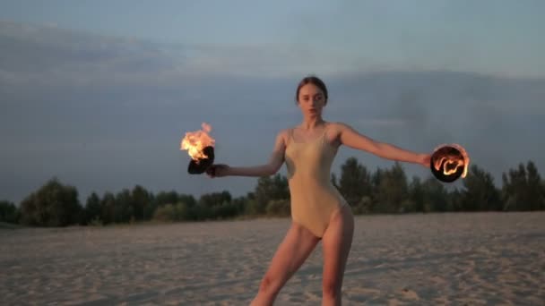 아름 다운 젊은 여 자가 사막에서 일출에 바디 슈트를 입고 불 춤 — 비디오