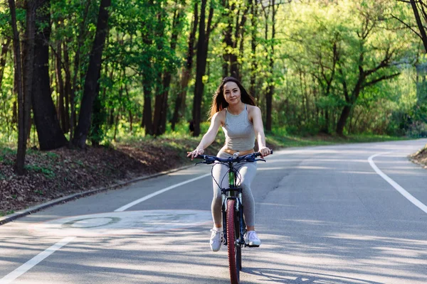 Young mixed race woman cyclist with mountain bike in the forest cycling workout outdoor.