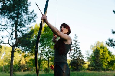 Ok ve yayla hedeflere ateş kadın kızıl saçlarını okçu. Konsantrasyon, hedef, başarı kavramı.