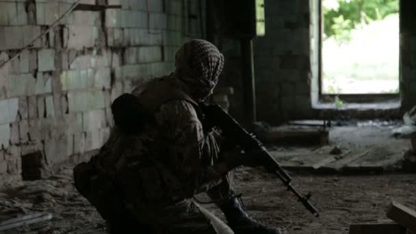 Guerilla partisan warrior operation in urban environment. Soldier aiming an enemy with his gun. — Stock Video