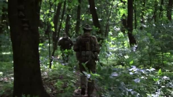 Escuadrón de guerreros guerrilleros corriendo en una formación llevando sus armas en los arbustos del bosque . — Vídeo de stock
