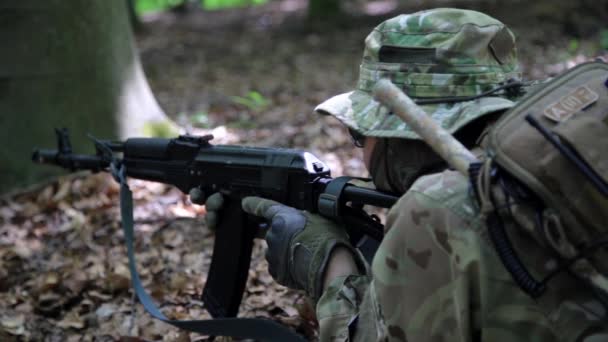 Guerrero partisano guerrillero apuntando en una emboscada forestal llevando su arma . — Vídeo de stock