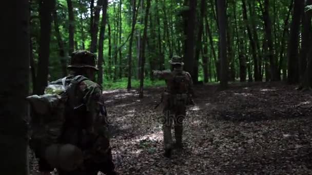 Guerilla partisan krigare promenader i skogen bakhåll bära sina kanoner. — Stockvideo
