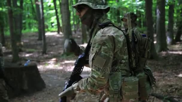 ゲリラ戦士部隊の司令官は森の茂みの中で彼の戦闘機を指示します。. — ストック動画