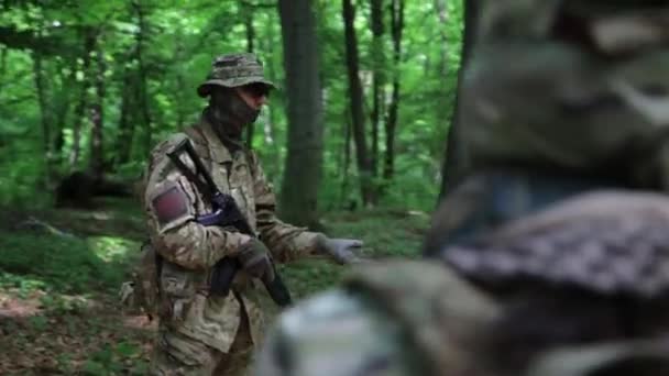Командир отряда партизан инструктирует своих бойцов в лесных кустах . — стоковое видео