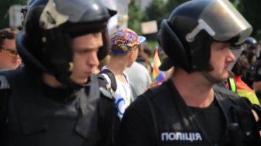 Kiev, Ukrayna - 18 Haziran: Polis güvenlik görevlisi gay geçit üzerinde Mart Kiev'de Eşcinsel tişört çocukla arka plan üzerinde