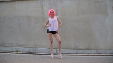 Genç güzel pembe peruk gri duvar arka plan üzerinde poz yarış kadın karışık.