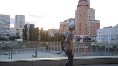 Son moda mutlu Asya öğrenci dansçı adam sokak Freestyle şehirde günbatımında dans.