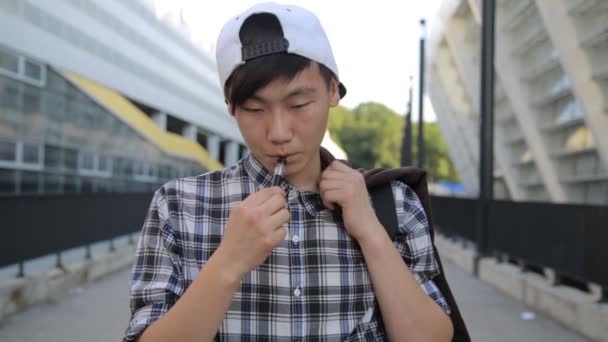 Ung Man gick på gatan och rök E-cigarett. Vape — Stockvideo