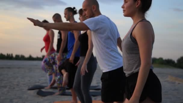 Grupo mixto de personas que practican yoga estilo de vida saludable fitness warrior poses — Vídeos de Stock