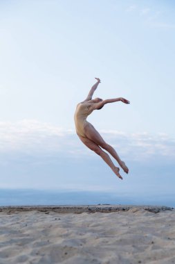 Genç güzel kadın giyiyor beden takım elbise çölde sunrise dans ediyor.