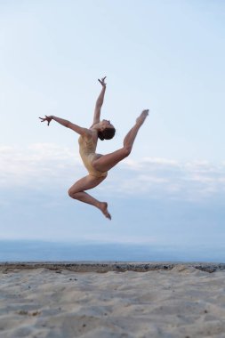 Genç güzel kadın giyiyor beden takım elbise çölde sunrise dans ediyor.