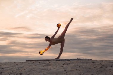 Genç güzel kadın beden takım elbise sunrise çölde ateşle dans ediyor