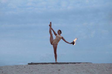 Genç güzel kadın beden takım elbise sunrise çölde ateşle dans ediyor