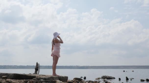 Mulher turística em belo vestido andando pela água para o horizonte. Experiência de viagem ao pôr-do-sol, menina desfrutando de um estilo de vida relaxado nas férias de verão — Vídeo de Stock