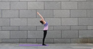 Kadın uygulamaları yoga fitness egzersiz şehrin gri kentsel zemin üzerine pembe mat
