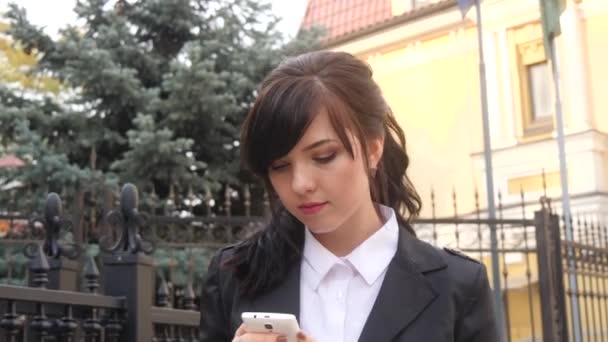 Atraktivní brunetka podnikatelka mluví na mobilním telefonu s klientem. — Stock video