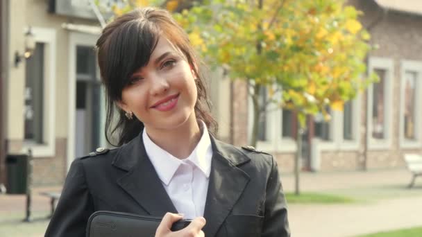 近代的なオフィスの背景に美しい笑顔ビジネスの女性。タブレットを保持. — ストック動画