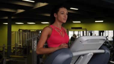Spor salonunda treadmill çalıştıran çekici karışık yarış kadının yakın çekim.