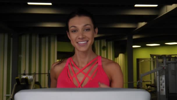 Close up de atraente mulher de raça mista correndo na esteira no ginásio esporte . — Vídeo de Stock