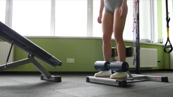 Smukłe piękne mieszanej rasy młoda kobieta ćwicząc w siłowni fitness studio w zwolnionym tempie — Wideo stockowe