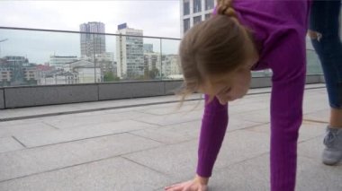 Genç çekici kadın akrobasi cityscape arka plan üzerinde ile yapıyor