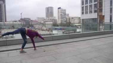 Genç çekici kadın akrobasi cityscape arka plan üzerinde ile yapıyor