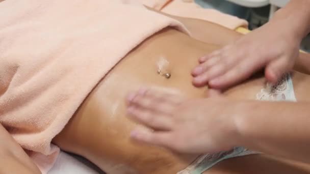 Μελαχρινή ταιριάζει γυναίκα πελάτης λαμβάνει κοιλιά μασάζ σώματος στο spa club από τατουάζ massagist — Αρχείο Βίντεο