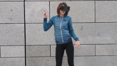 Mutlu sanal oyun oynamayı ve tarassut video açık havada şehirdeki sokak dans vr gözlük, kulaklık, genç bir kadın. Duygular
