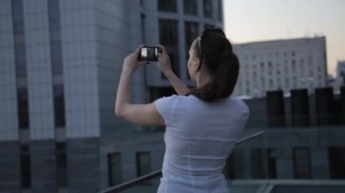 İşkadını smartphone ile şehrin Panorama video fotoğraf yapma.