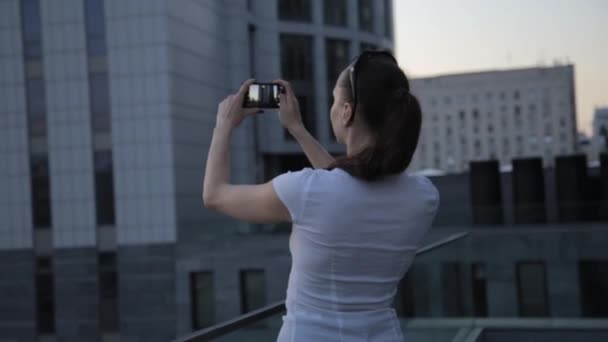 Geschäftsfrau macht mit Smartphone Panoramafoto der Stadt. — Stockvideo