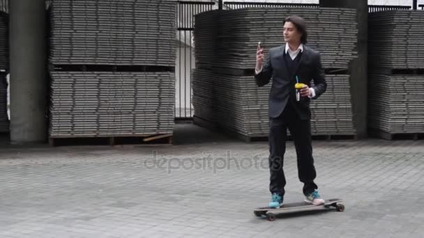 年轻有吸引力的商业男子办公室工人骑滑板上班。喝拿铁咖啡和电话聊天混合种族拉丁裔西班牙族裔. — 图库视频影像