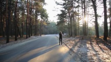 İnce bir rakam olan kadın jimnastik güneş doğarken devreye girer. O orman koşmak yapar.