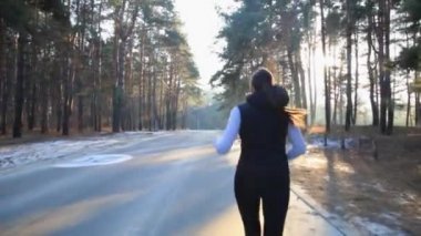 İnce bir rakam olan kadın jimnastik güneş doğarken devreye girer. O orman koşmak yapar.