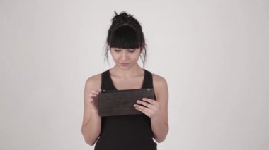 El tutan genç çekici İspanyol latina kadın portresi closeup tablet Pc üzerinde açık gri renkli izole