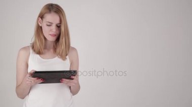 Tablo Pc bilgisayar ile ışık gri arka plan üzerinde duran mutlu kadın. Alan metni kopyalayın.