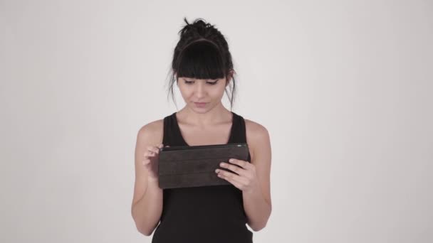 Closeup portrait of young attractive hispanic latina woman holding handheld tablet PC isolated on light grey background — Stock Video