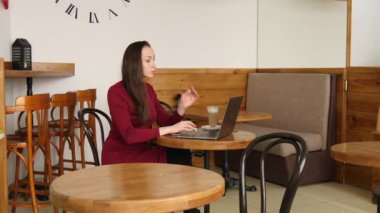 Kırmızı elbise çalışma sütlü kahve içme kahve dizüstü bilgisayar, iş kadını