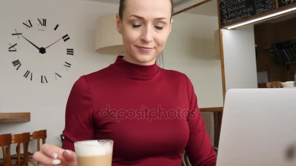 Mujer de negocios en vestido rojo Trabajando en el ordenador portátil en Café Beber café Latte — Vídeo de stock