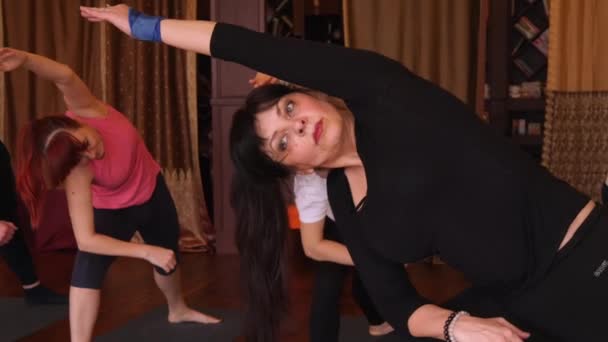 Lezione di yoga di persone che esercitano uno stile di vita sano in palestra yoga . — Video Stock