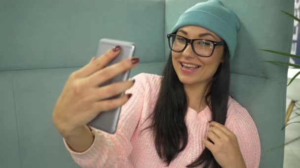 Mixed race young hipster woman makes selfie with coffee while sitting in cafe — Stock Video