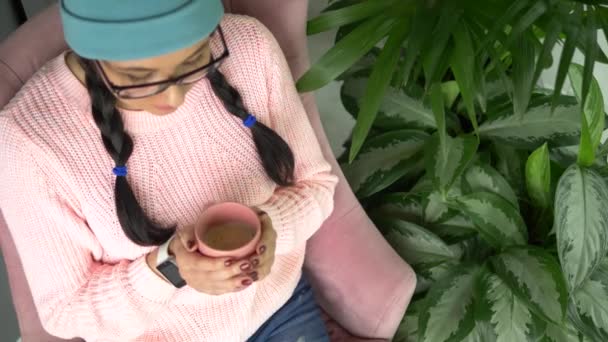 Blandad ras hipster kvinna sitter i café, dricka kaffe och med smartphone — Stockvideo